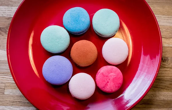 French colorful macarons on a red plate. Restaurant. — Stock Photo, Image