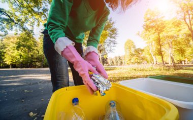 Gönüllü kız parkın sokaklarındaki çöpleri ayıklıyor. Geri dönüşüm kavramı. 