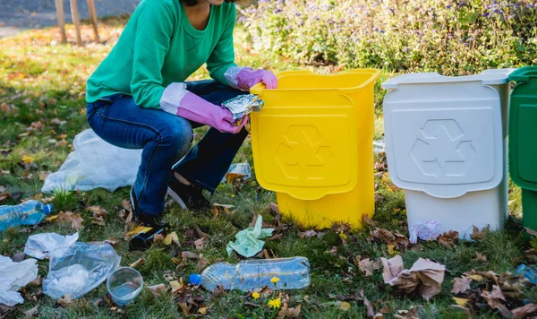 Девушка-волонтёр сортирует мусор на улице парка. Концепция переработки . — стоковое фото