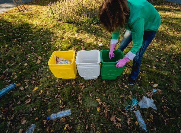 Volunteer girl sorts garbage in the street of the park. Concept of recycling. — 스톡 사진