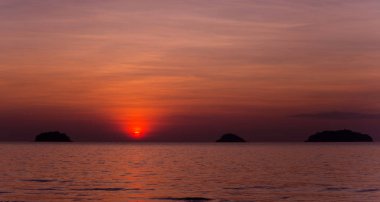 Tropiklerdeki sahilde güzel bir gün batımı. Gökyüzü ve okyanus