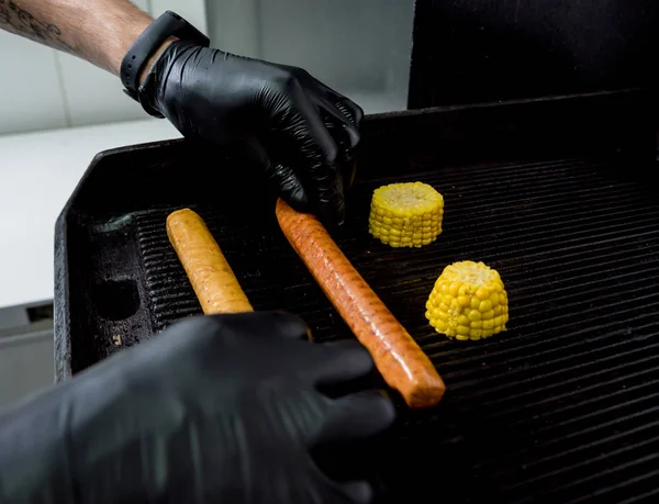 Šéfkuchař vaří dva hot dogy na grilu. Restaurace. — Stock fotografie