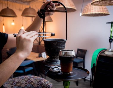 Barda nargile pişirmek. Lokantada nargilesi olan genç adam.