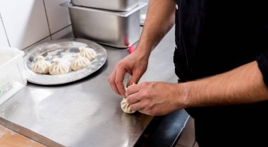 Aşçı Gürcü Khinkali ya da Japon wontonu pişiriyor. Geleneksel yemek 