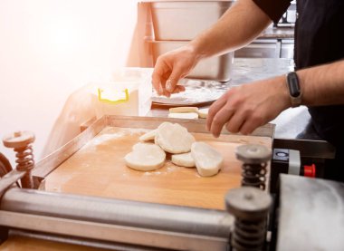 Chef preparing dough for pastry, dumplings, italian pasta or japanese wontons.