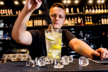 Barmen barda kokteyl hazırlıyor. Taze kokteyller. Barmen iş başında..