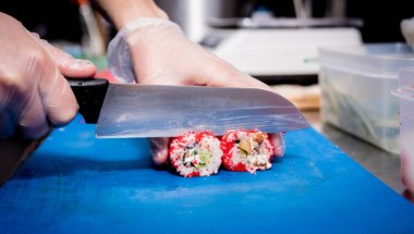 Restoranın mutfağında suşi ve ekmek yapma süreci. Şefin elleri bıçaklı..
