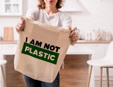 Young girl holding a cloth bag. At the kitchen. I am not plastic. 