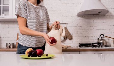 Young girl holding a cloth bag. At the kitchen. I am not plastic. 