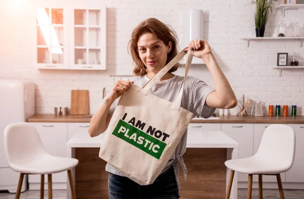 Young girl holding a cloth bag. At the kitchen. I am not plastic. 