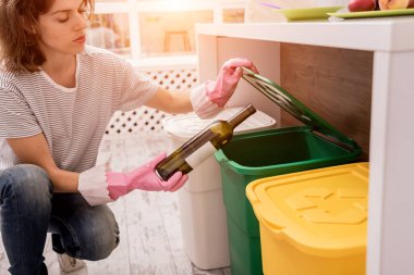 Mutfakta çöpleri ayıran genç bir kız. Geri dönüşüm kavramı. Sıfır atık