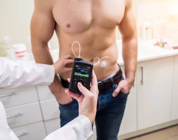 The doctor connects an insulin pump to a patient with diabetes. — Stock Photo, Image