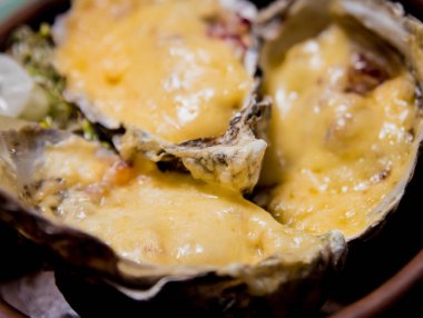 Peynirin altında taze istiridye, buz ve çiçeklerle dolu bir tabakta. Restoran