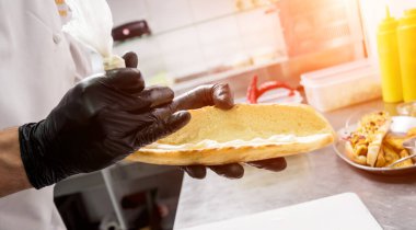 Şef ızgarada sosisli pişiriyor. Restoran.