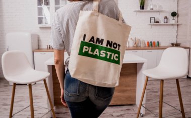 Young girl holding a cloth bag. At the kitchen. I am not plastic. 