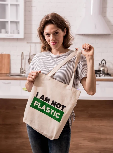 Young girl holding a cloth bag. At the kitchen. I am not plastic.