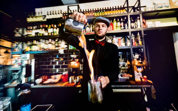 El camarero hace un cóctel con un espectáculo de fuego en el bar . — Foto de Stock