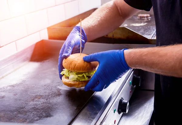 Chef preparando hamburguesas en la cocina parrilla estufa. Restaurante . — Foto de Stock