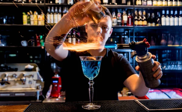 Barman robi koktajl z pokazem ognia w barze. Barman w pracy. — Zdjęcie stockowe