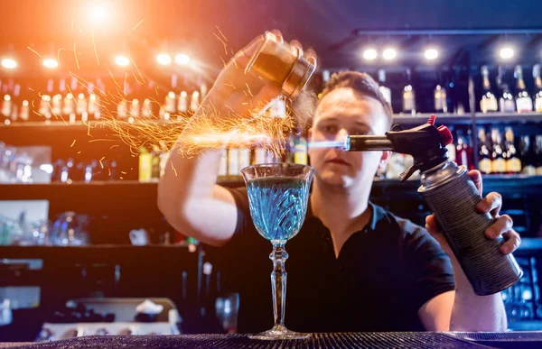 A csapos koktélt készít egy tűzshow-val a bárban. Csapos a munkahelyen. — Stock Fotó