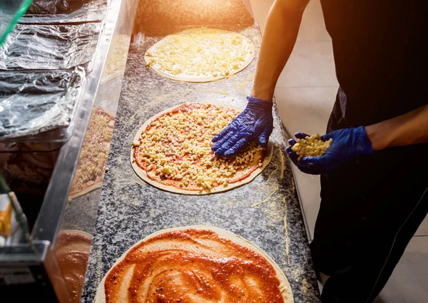 Den Prozess der Herstellung von Pizza. Hände des Chefbäckers backen Pizza in der Caféküche — Stockfoto