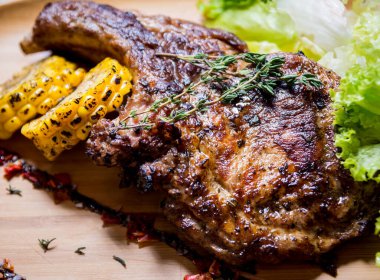 Tahtada mısır ve salata ile ızgara domuz pirzolası.