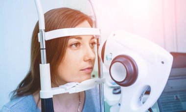Doctor examining womans eyes with a measurement machine.