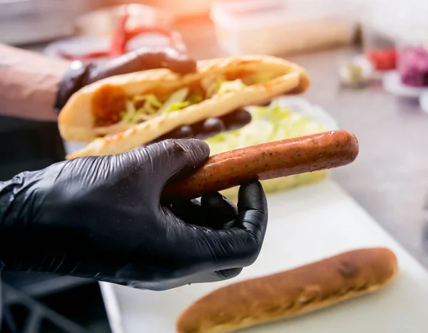 Šéfkuchař vaří hot dog na grilu. Restaurace. — Stock fotografie