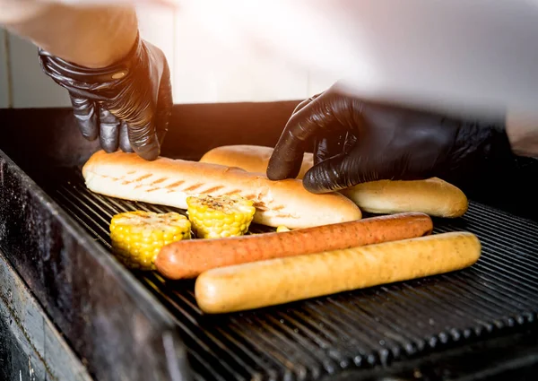 Šéfkuchař vaří dva hot dogy na grilu. Restaurace. — Stock fotografie