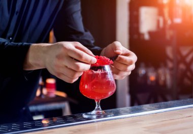 Barmen barda kokteyl hazırlıyor. Taze kokteyller. Barmen iş başında..