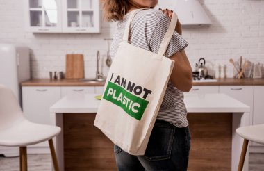 Young girl holding a cloth bag. At the kitchen. I am not plastic. 