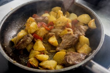 Şef, restoranın mutfağında kızarmış patates pişiriyor.