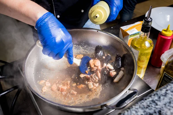 Şef tavada midye ile makarna pişiriyor. İtalyan mutfağı. Restoran. — Stok fotoğraf