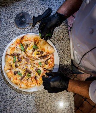 Pizza yapma süreci. Kafe mutfağında pizza yapan aşçının elleri.