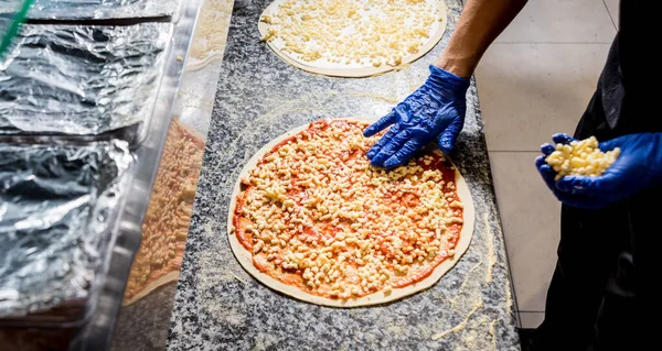 The process of making pizza. Hands of chef baker making pizza at cafe kitchen — Stock Photo, Image