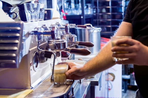 The bartender makes the coffee, cappuccino, cocoa, drink at the bar. Barista.