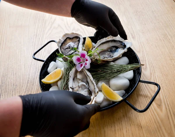 Chef opens a fresh oyster. Dish with open oysters. Restaurant. — 스톡 사진