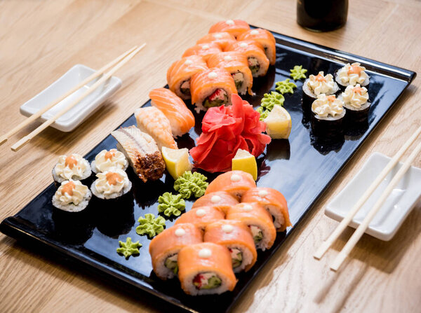 Sushi set. Rolls with salmon, eel and red caviar on a wooden plate. Restaurant.