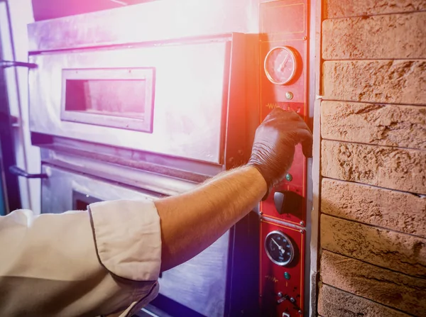 The process of making pizza. Chef baker puts raw pizza in the oven. Kitchen. — Stock Photo, Image