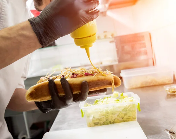 Le chef cuisinier hot dog sur un gril. Restaurant . — Photo