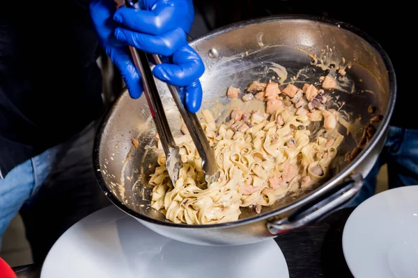 Chef cocinando pasta con mejillones en sartén. Cocina de estilo italiano. Restaurante . — Foto de Stock