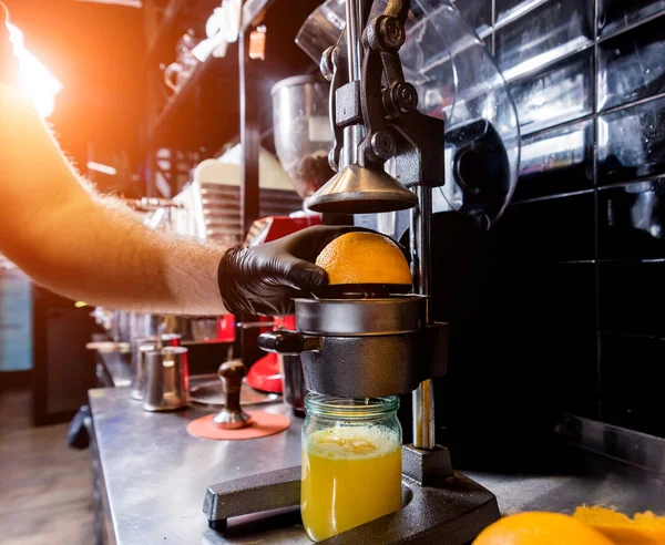 Kovový ruční odšťavňovač. Příprava čerstvě vymačkaného pomerančového džusu — Stock fotografie
