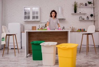 Mutfakta çöpleri ayıran genç bir kız. Geri dönüşüm kavramı. Sıfır atık