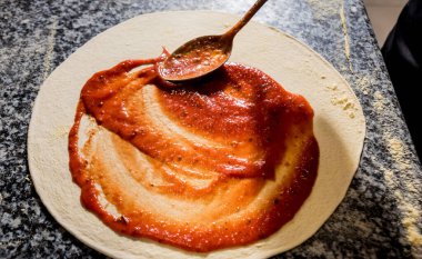 Pizza yapma süreci. Kafe mutfağında pizza yapan aşçının elleri.