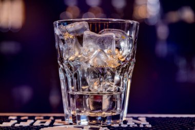 Alcoholic cocktail with ice at wooden bar counter. Restaurant.