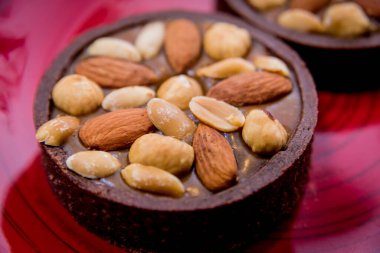 Kırmızı tabakta badem fıstıklı çikolatalı kurabiyeler. Restoran.