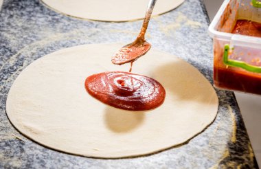 Pizza yapma süreci. Kafe mutfağında pizza yapan aşçının elleri.