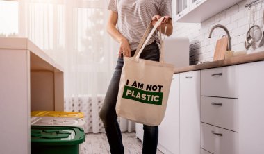 Young girl holding a cloth bag. At the kitchen. I am not plastic. 