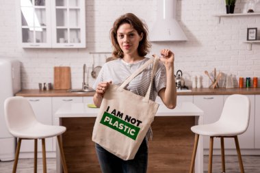 Young girl holding a cloth bag. At the kitchen. I am not plastic. 