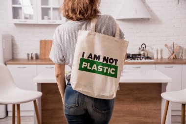 Young girl holding a cloth bag. At the kitchen. I am not plastic. 